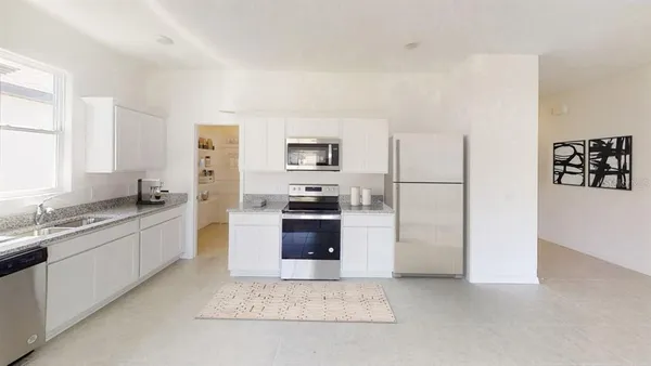 a large kitchen with a refrigerator sink and stove
