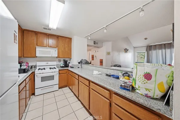 a kitchen with granite countertop lots of clutter and stainless steel appliances