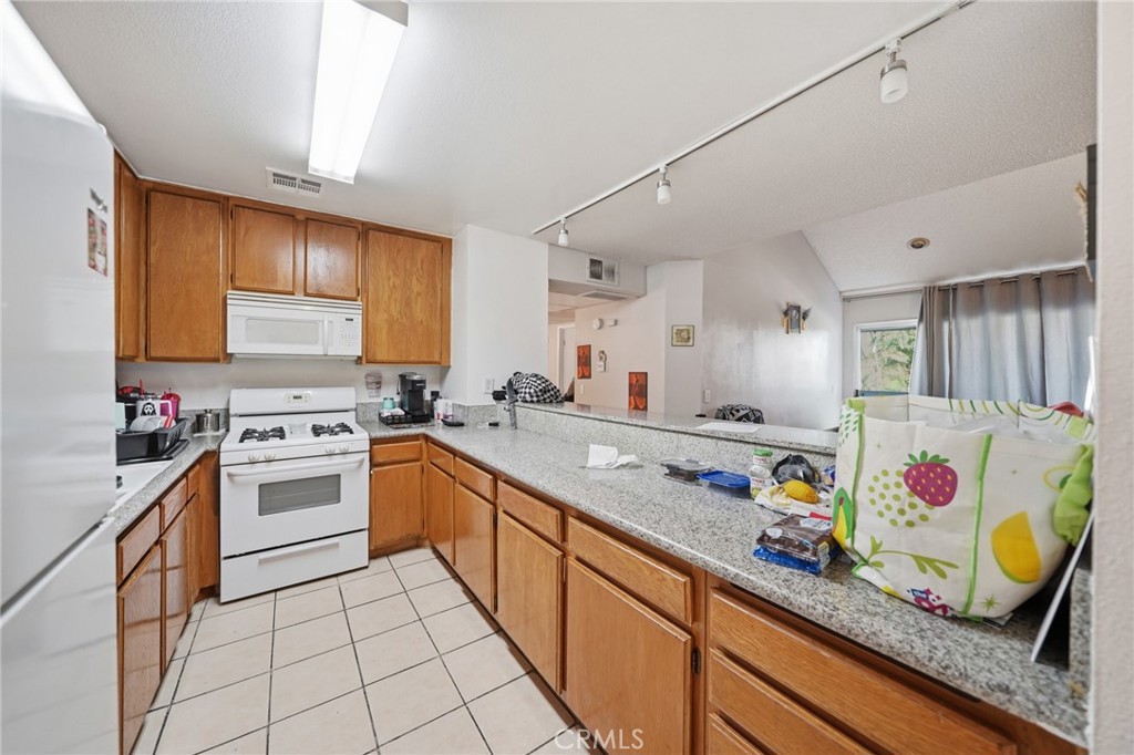 7640 Oso Avenue, Unit 318 Winnetka, CA 91306 - Photo 14 of 43 a kitchen with granite countertop lots of clutter and stainless steel appliances