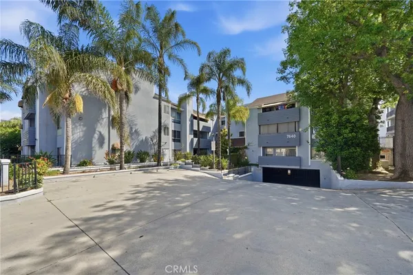 a row of palm trees in front of a building