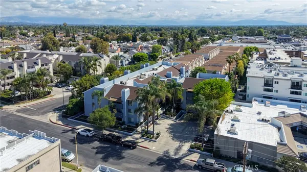 an aerial view of a residential houses with yard and mountain view in back