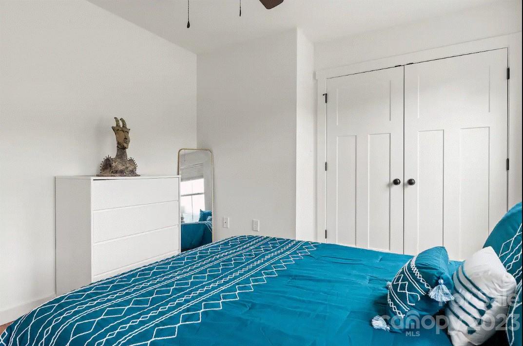 231 Medford Branch Road Candler, NC 28715 - Photo 22 of 28 a bedroom with a bed and wooden floor