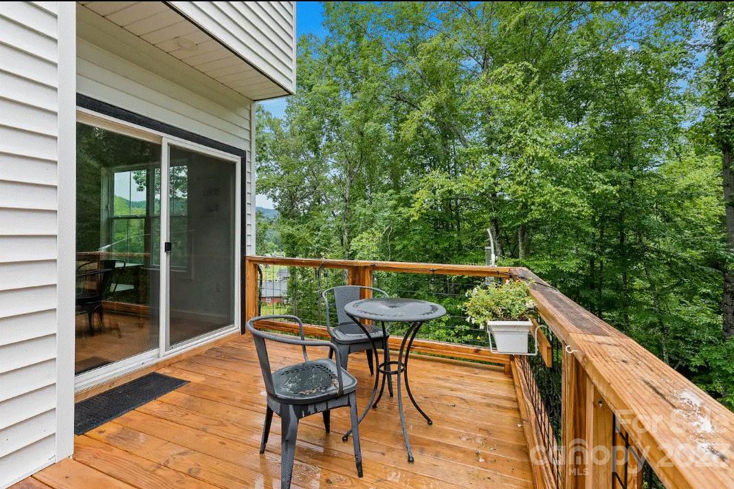 231 Medford Branch Road Candler, NC 28715 - Photo 26 of 28 a balcony with wooden floor and outdoor seating