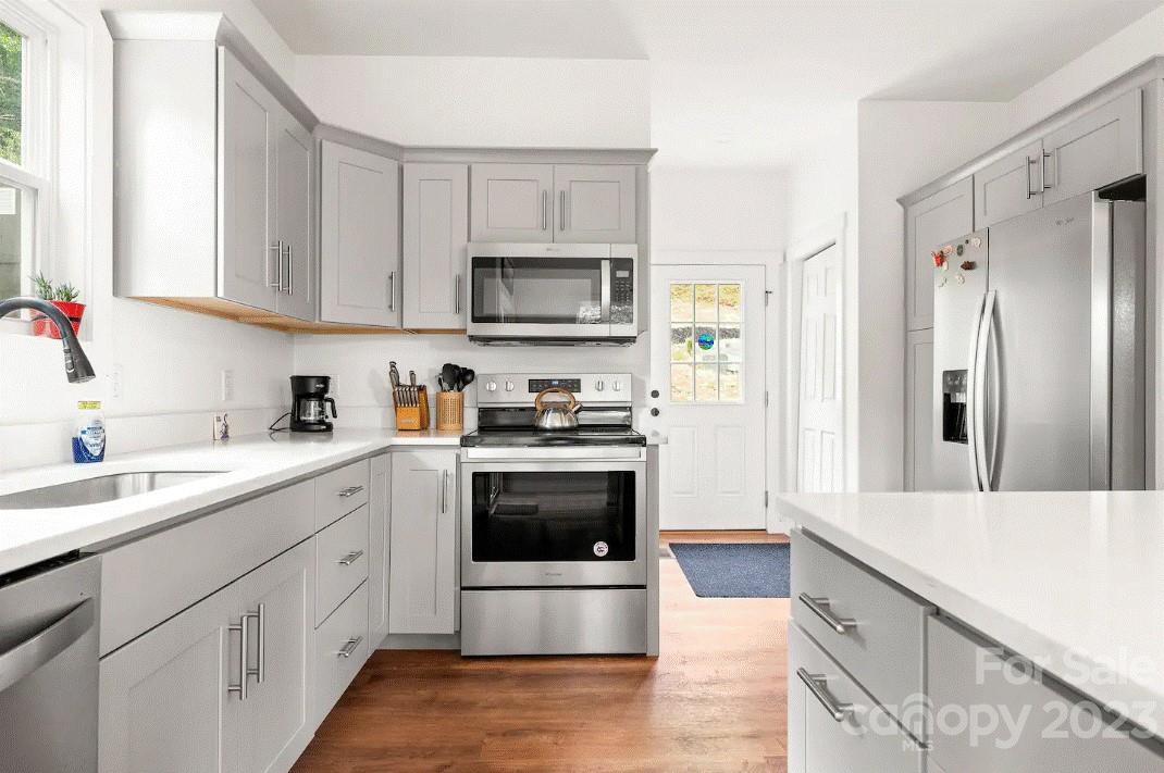 231 Medford Branch Road Candler, NC 28715 - Photo 10 of 28 a kitchen with stainless steel appliances granite countertop a refrigerator sink and stove