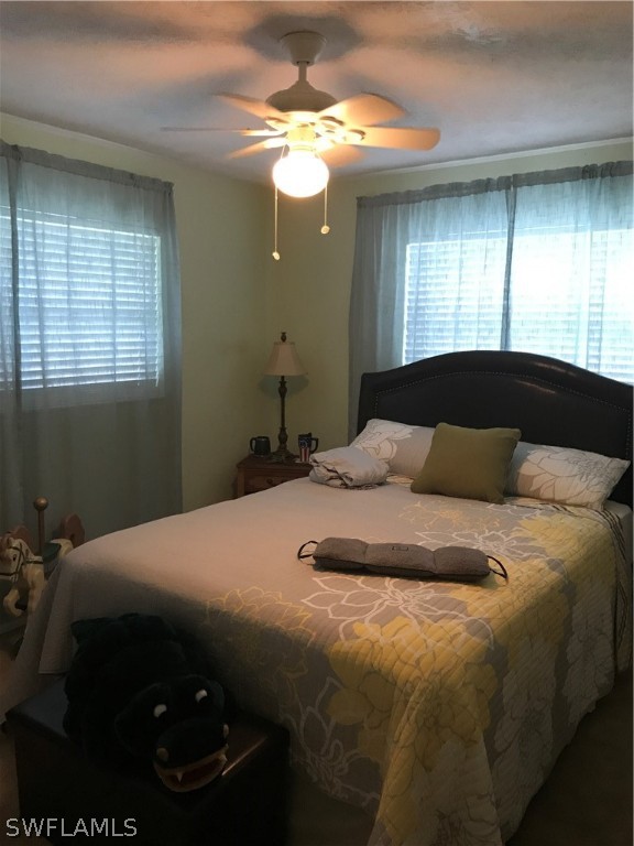 2719 W Road Fort Myers, FL 33905 - Photo 5 of 15 a bedroom with a bed and a chandelier
