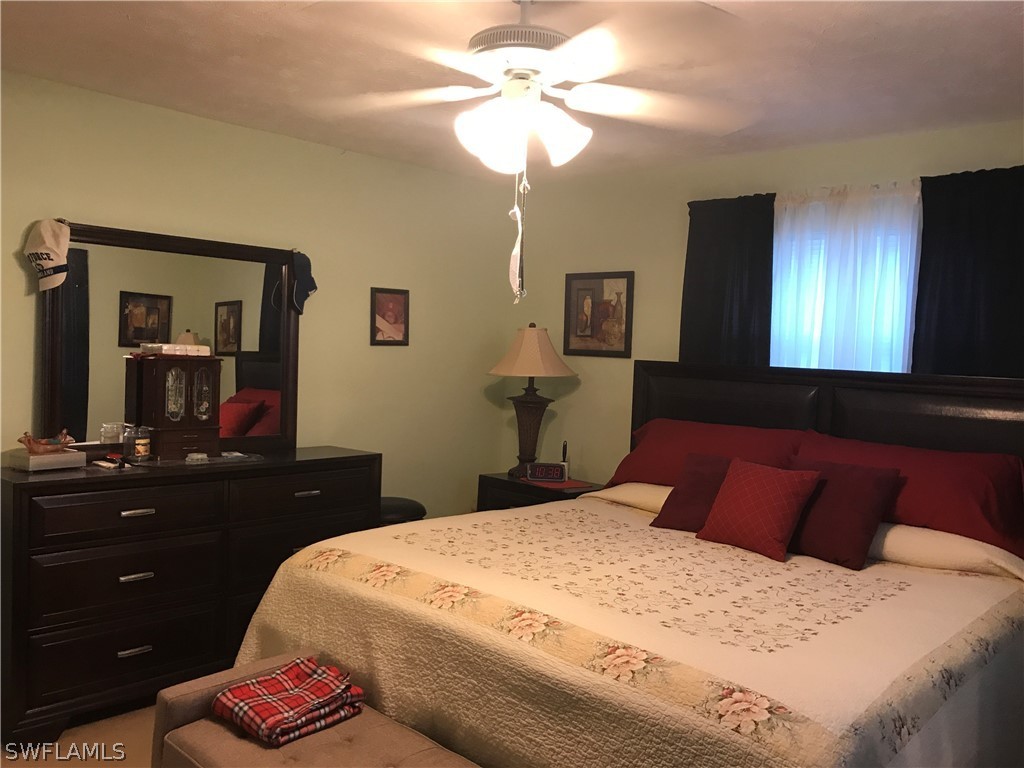2719 W Road Fort Myers, FL 33905 - Photo 10 of 15 a bedroom with a bed and a chandelier