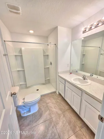 a bathroom with a double vanity sink toilet mirror and bathtub