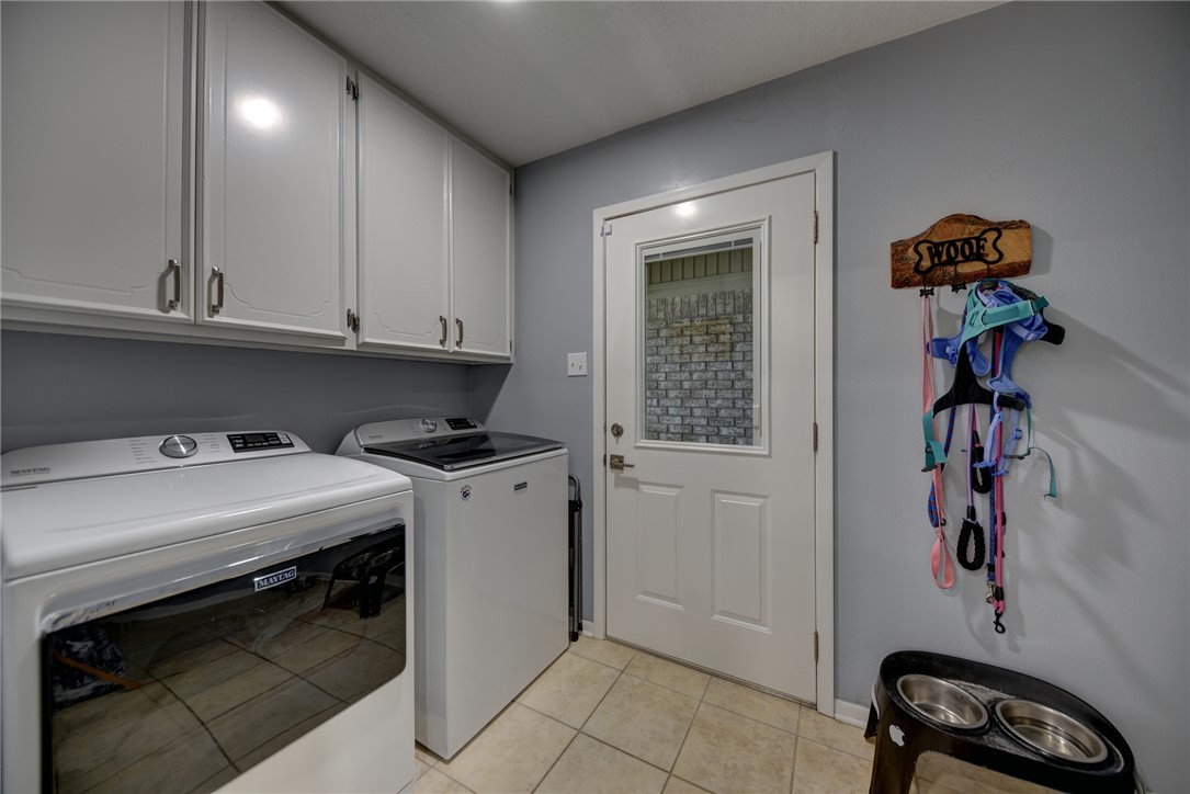 1600 Pecan Street Brenham, TX 77833 - Photo 26 of 33 Laundry area featuring cabinets, washer and clothes dryer, tile floors, baseboards and space for a freezer