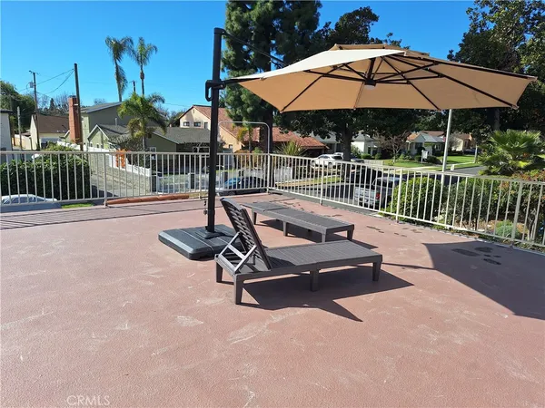 a view of a patio with a table and chairs under an umbrella