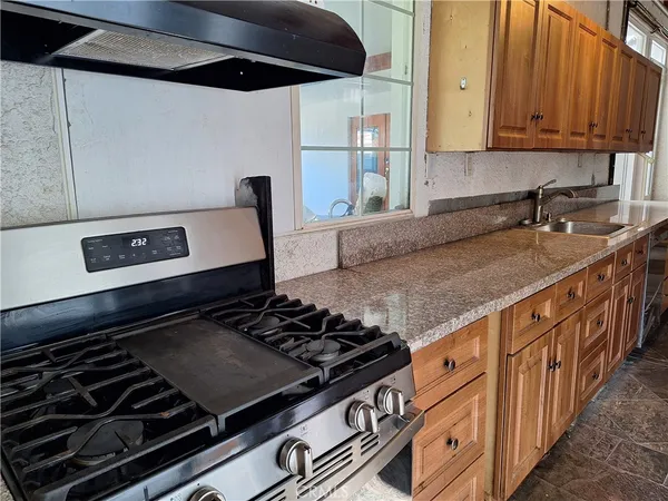 a kitchen with granite countertop a stove and a sink