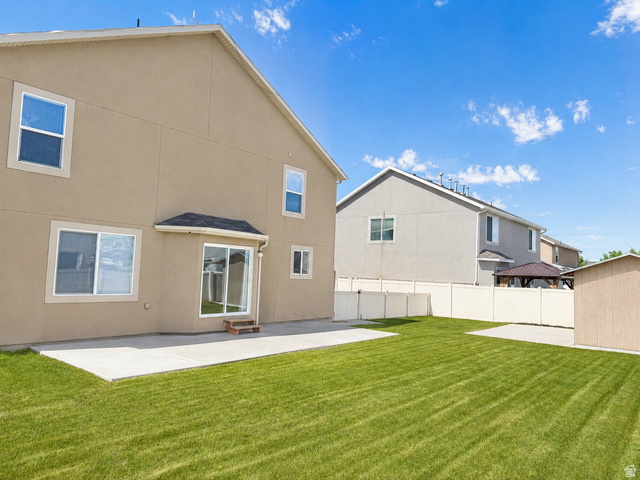 1038 West 950 South Springville, UT 84663 - Photo 14 of 14 Expansive backyard featuring a manicured lawn, concrete patio, and mature privacy fencing