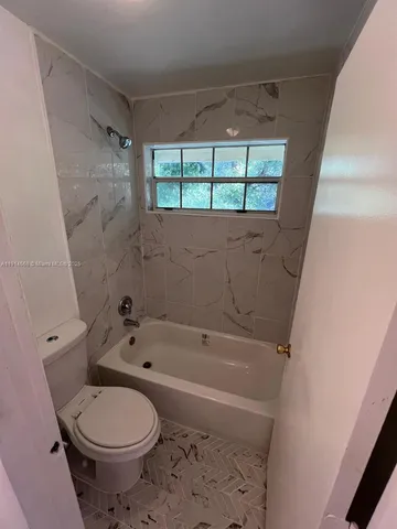 a bathroom with a toilet and a bathtub