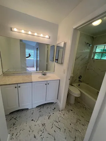 a bathroom with a sink a toilet and mirror