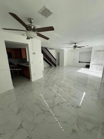 a view of a livingroom with furniture and a ceiling fan