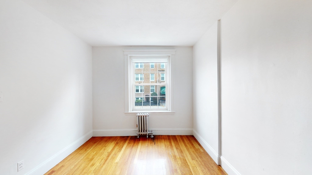 120 Summer Street, Unit 1 Malden, MA 02148 - Photo 8 of 14 a view of an empty room with a window and wooden floor