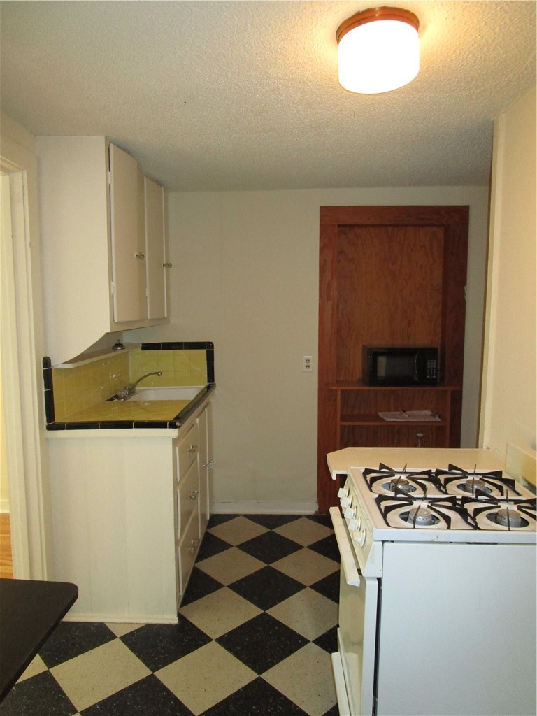 908 West 22nd Street, Unit E Austin, TX 78705 - Photo 3 of 4 a kitchen with a stove a sink and a refrigerator