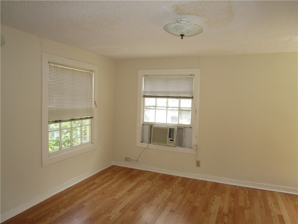 908 West 22nd Street, Unit E Austin, TX 78705 - Photo 4 of 4 a view of an empty room with wooden floor and a window