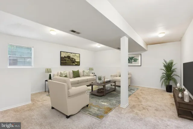 a living room with furniture and a potted plant