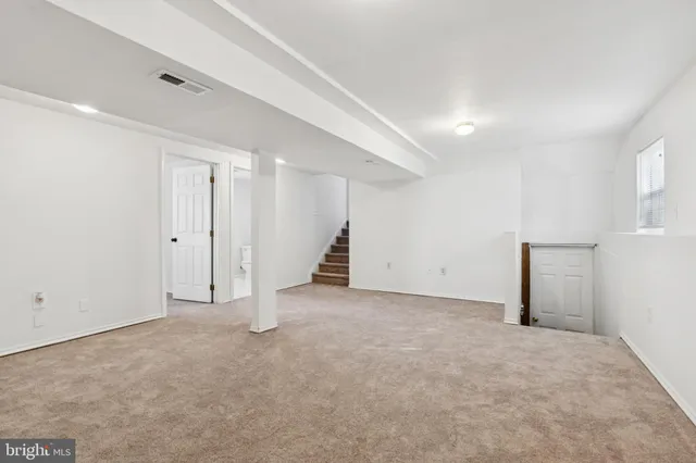 an empty room with a hallway and stairs