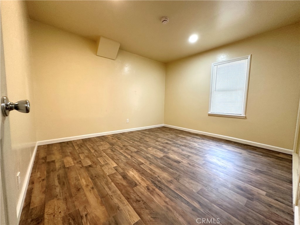 828 West 23rd Street Merced, CA 95340 - Photo 9 of 19 an empty room with wooden floor and windows