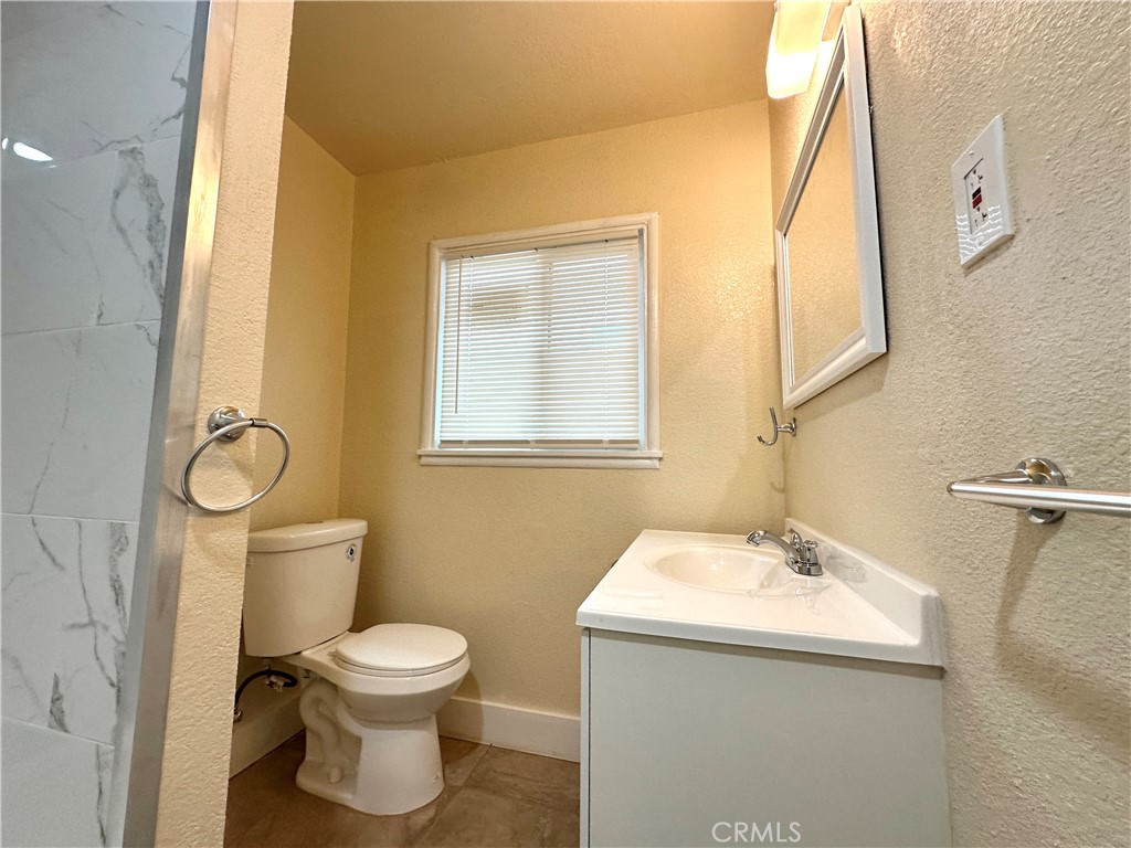 828 West 23rd Street Merced, CA 95340 - Photo 10 of 19 a bathroom with a toilet sink and mirror