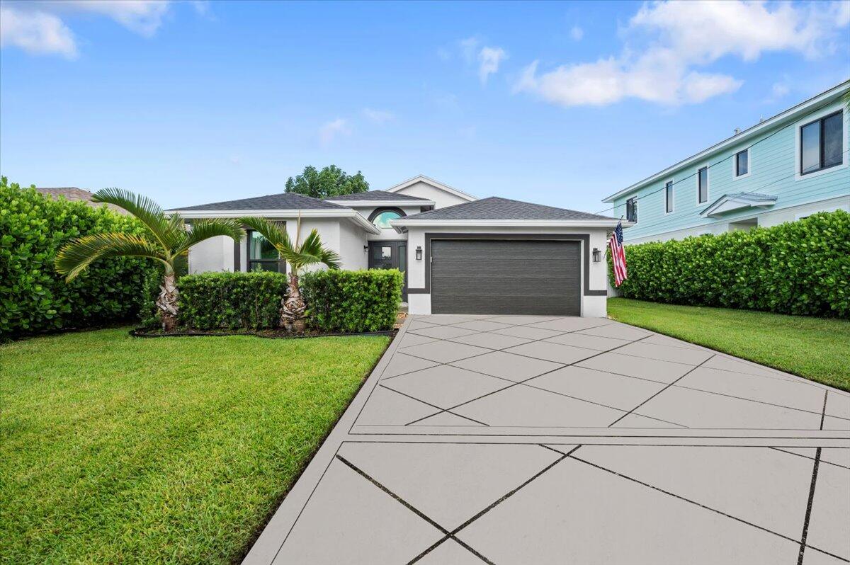 6430 Barbara Street Jupiter, FL 33458 - Photo 1 of 18 a front view of a house with a yard and garage