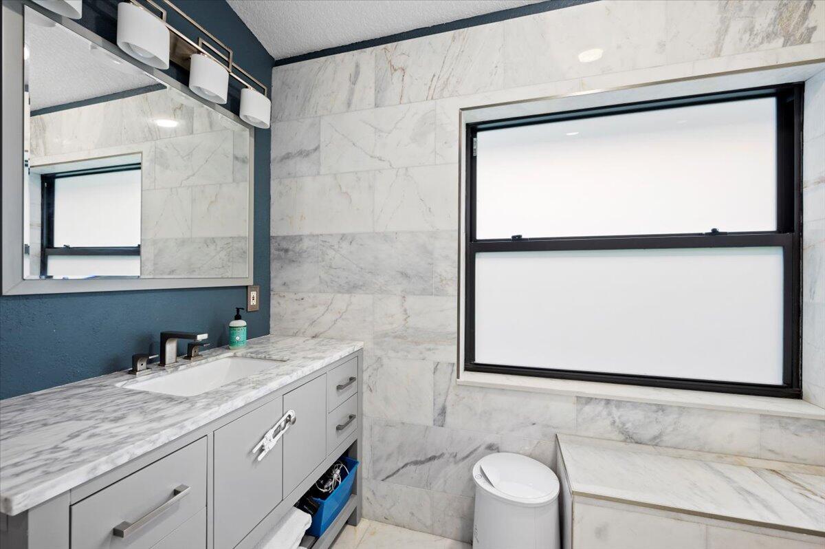 6430 Barbara Street Jupiter, FL 33458 - Photo 11 of 18 a bathroom with a double vanity sink and mirror