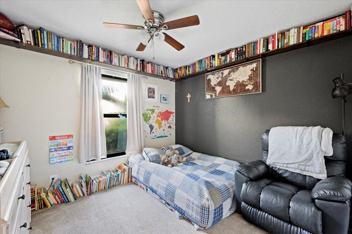 6430 Barbara Street Jupiter, FL 33458 - Photo 12 of 18 a bedroom with furniture and a book shelf
