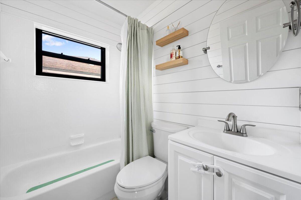 6430 Barbara Street Jupiter, FL 33458 - Photo 14 of 18 a bathroom with a toilet sink and a bathtub