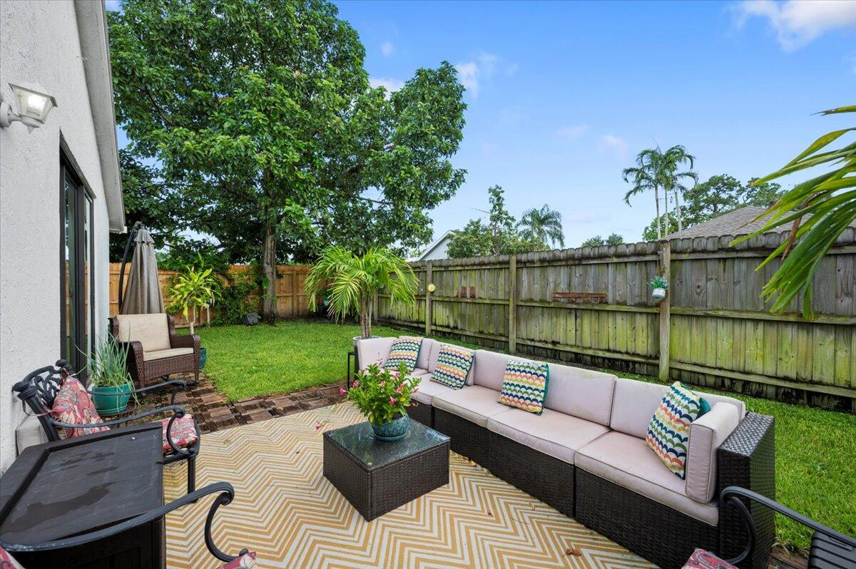 6430 Barbara Street Jupiter, FL 33458 - Photo 18 of 18 a view of a backyard with couches potted plants and a large tree