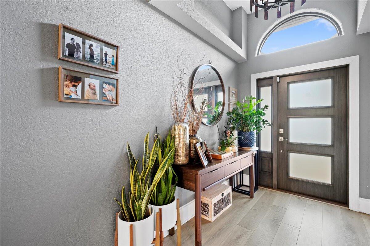 6430 Barbara Street Jupiter, FL 33458 - Photo 2 of 18 a living room with furniture a potted plant and a painting on the wall