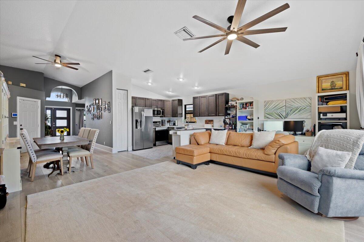 6430 Barbara Street Jupiter, FL 33458 - Photo 3 of 18 a living room with furniture kitchen view and a chandelier