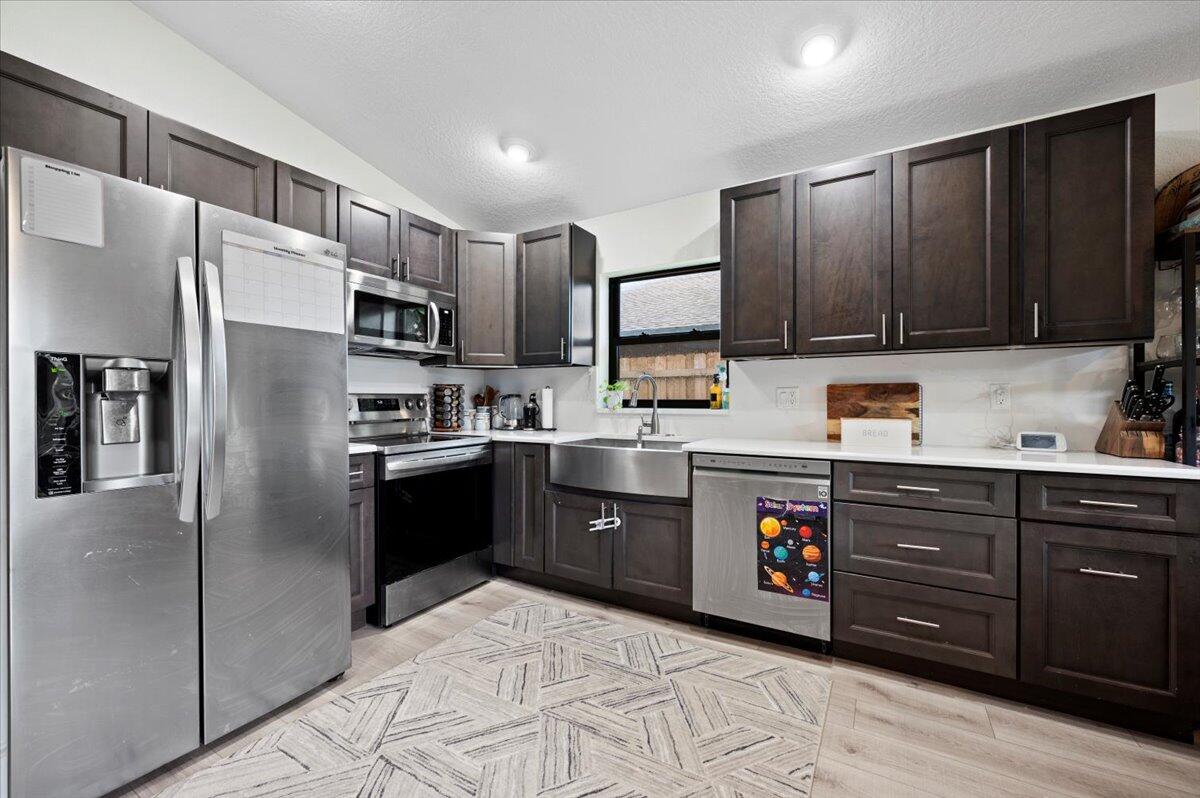 6430 Barbara Street Jupiter, FL 33458 - Photo 7 of 18 a kitchen with stainless steel appliances granite countertop a refrigerator and a stove top oven