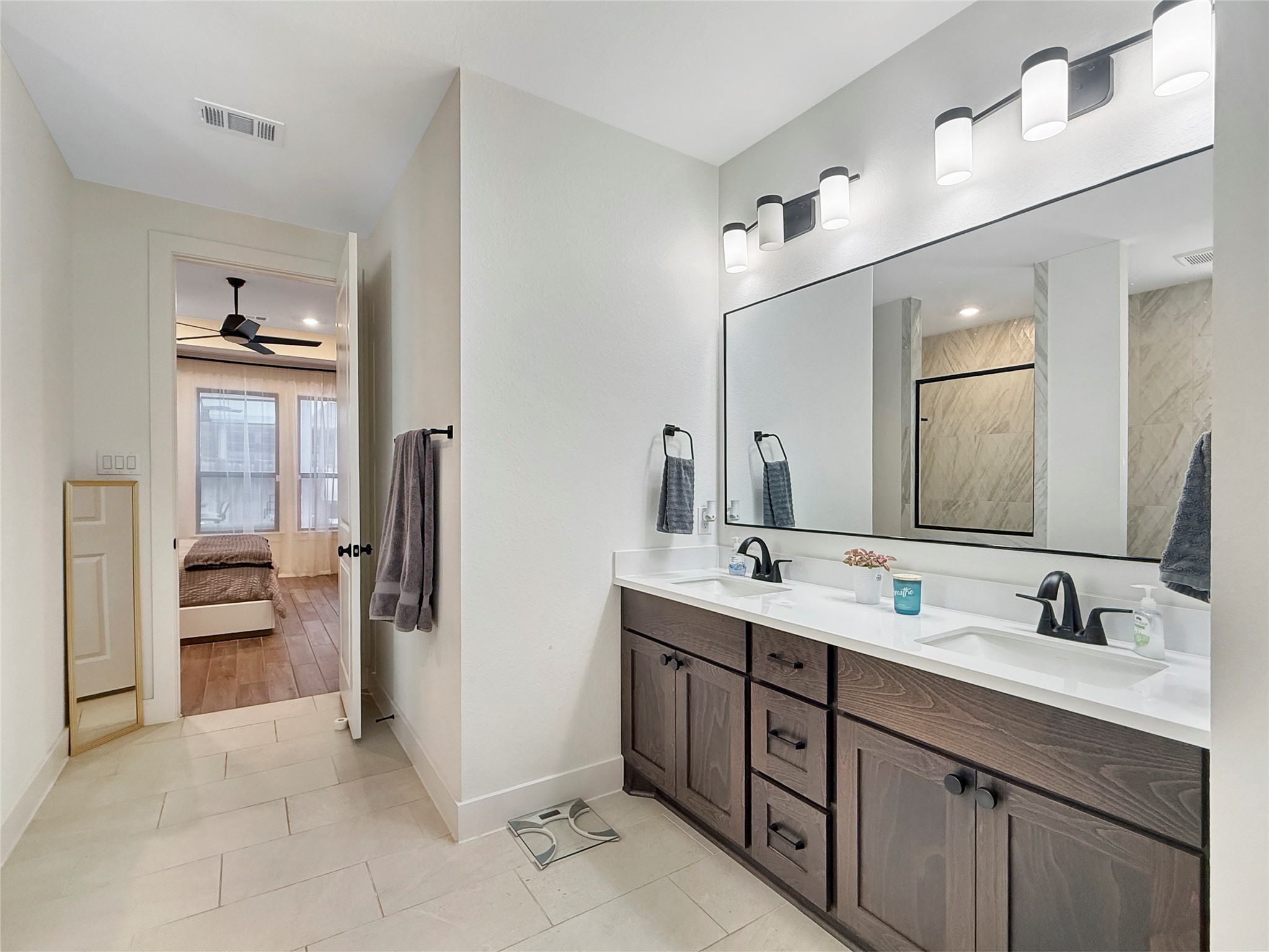 26918 Swanborough Road Spring, TX 77389 - Photo 22 of 50 His-and-hers sinks, abundant counter space, and rich wood cabinetry make this primary bath as functional as it is elegant, with direct access to the bedroom retreat.