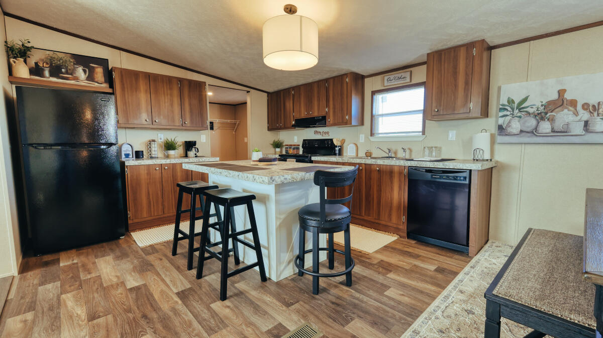 508 Sage Road Tahoka, TX 79373 - Photo 8 of 32 a kitchen with stainless steel appliances granite countertop a stove a refrigerator a sink a dining table and chairs with wooden floor
