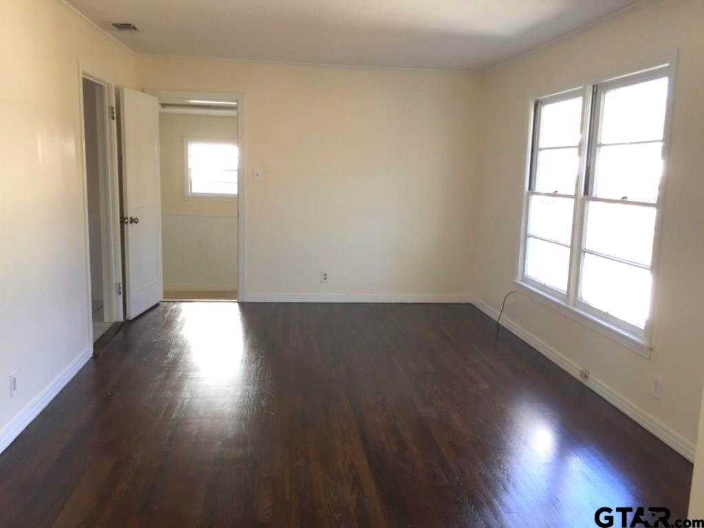 509 North Line Street Mineola, TX 75773 - Photo 2 of 16 an empty room with wooden floor and windows