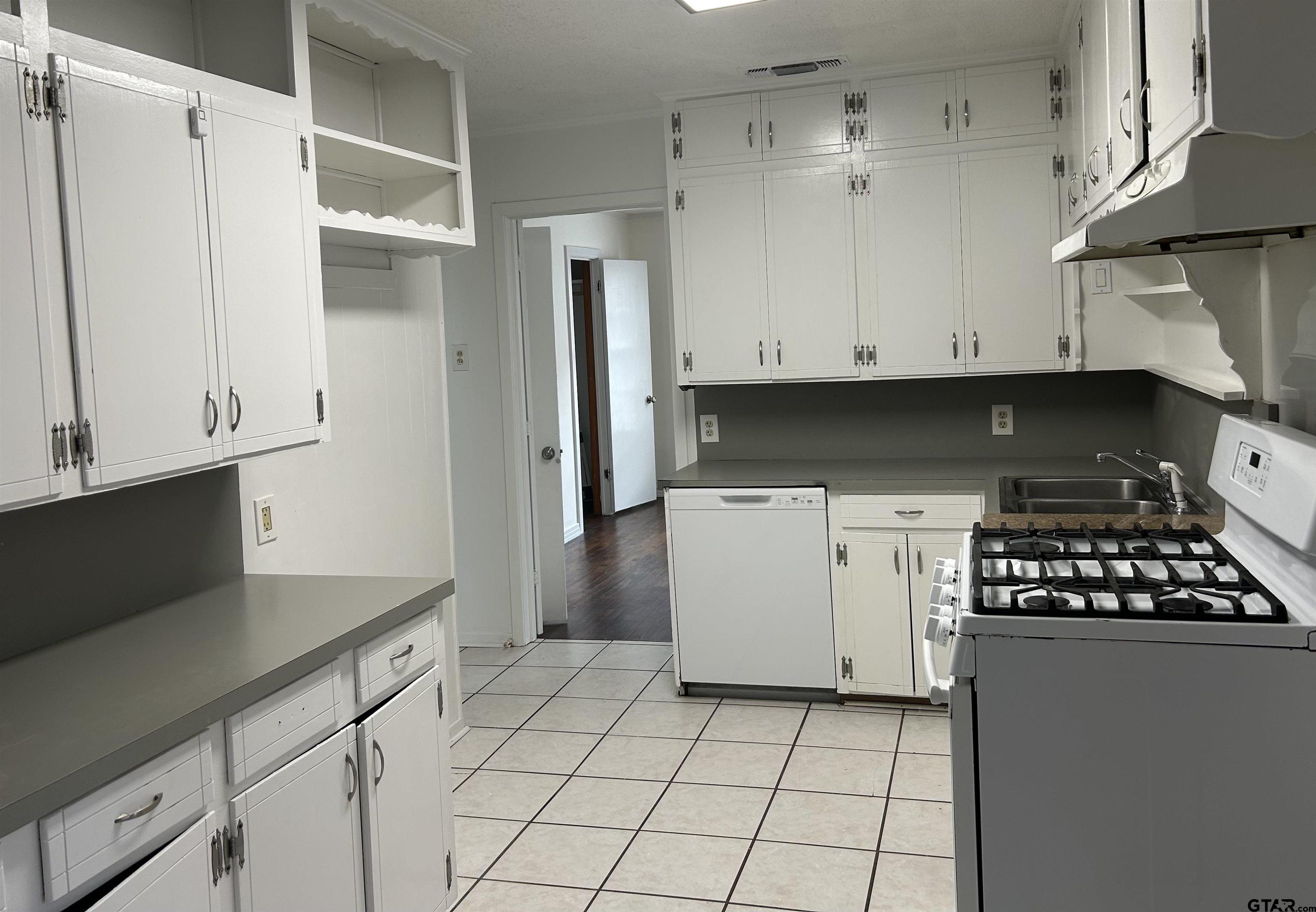 509 North Line Street Mineola, TX 75773 - Photo 4 of 16 a kitchen with cabinets and white appliances