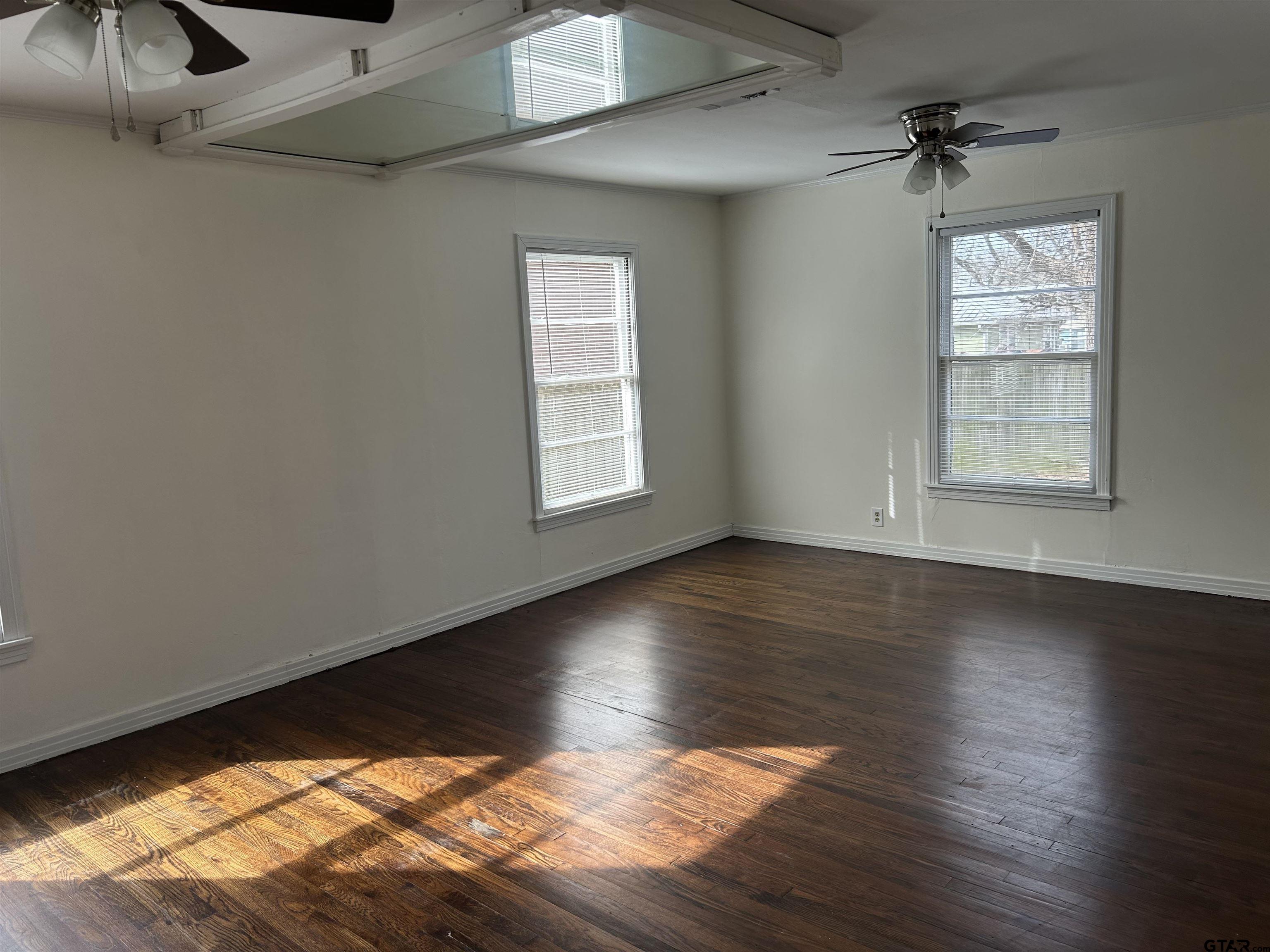 509 North Line Street Mineola, TX 75773 - Photo 8 of 16 an empty room with wooden floor and windows
