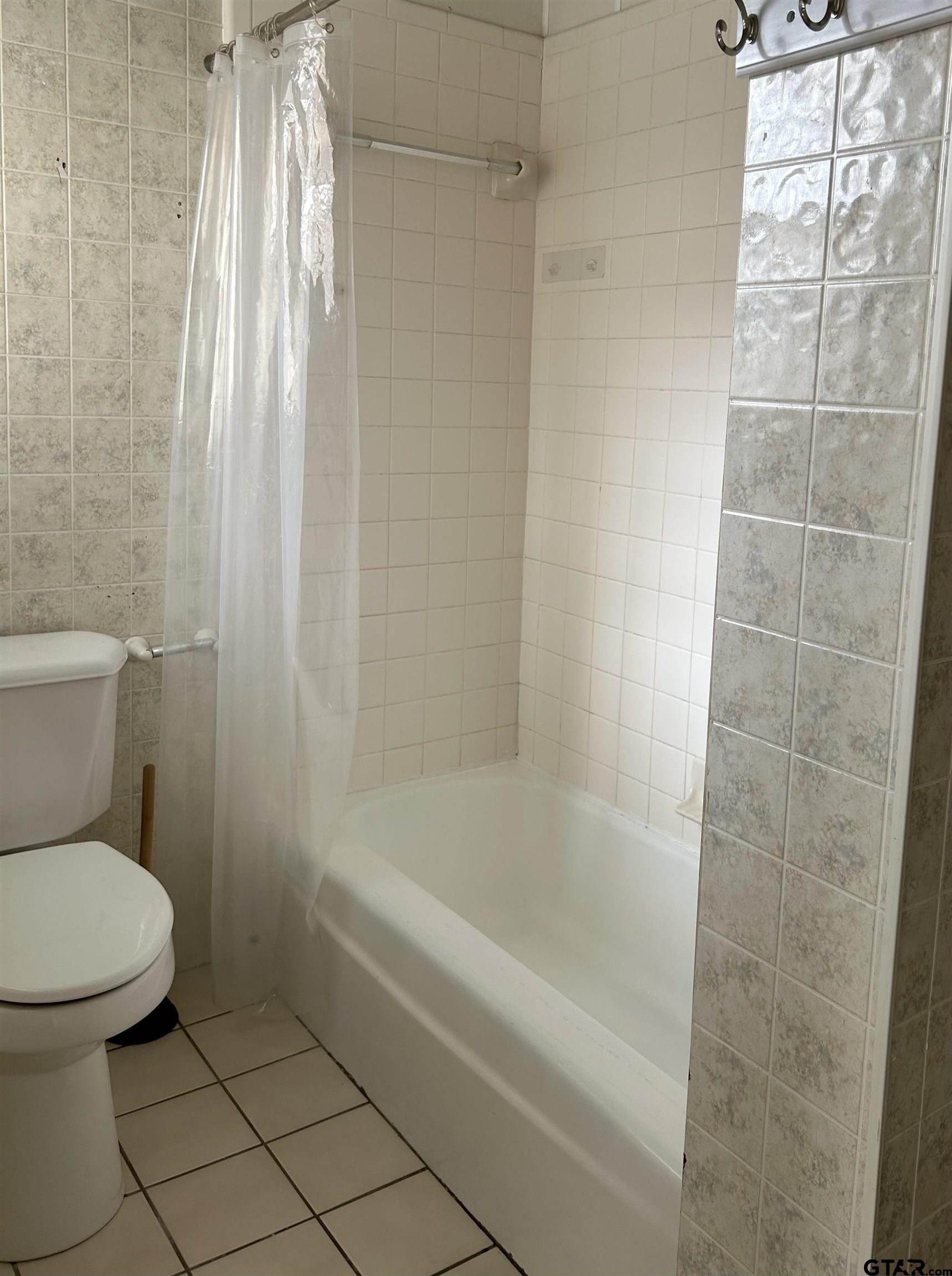 509 North Line Street Mineola, TX 75773 - Photo 10 of 16 a white toilet sitting next to a bath tub