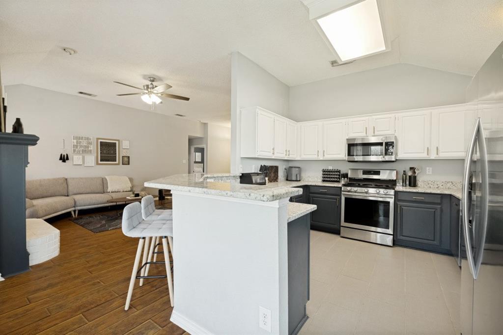11709 Harbor Road Frisco, TX 75035 - Photo 4 of 12 a kitchen with a sink stainless steel appliances and white cabinets