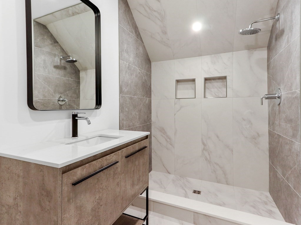 1917 Commonwealth Avenue, Unit 1917 Newton, MA 02466 - Photo 24 of 30 a bathroom with a sink a mirror and shower