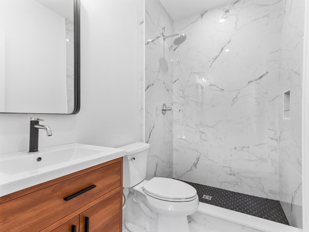 1917 Commonwealth Avenue, Unit 1917 Newton, MA 02466 - Photo 27 of 30 a bathroom with a sink a toilet and shower