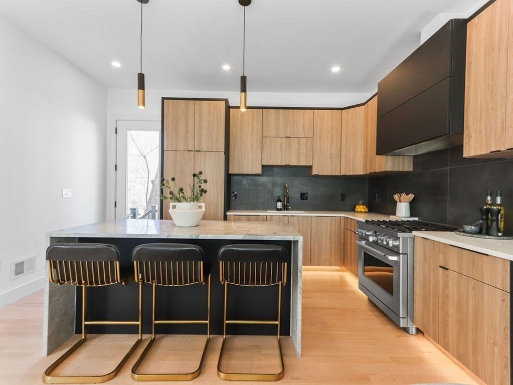 1917 Commonwealth Avenue, Unit 1917 Newton, MA 02466 - Photo 5 of 30 a kitchen with a table chairs sink and cabinets