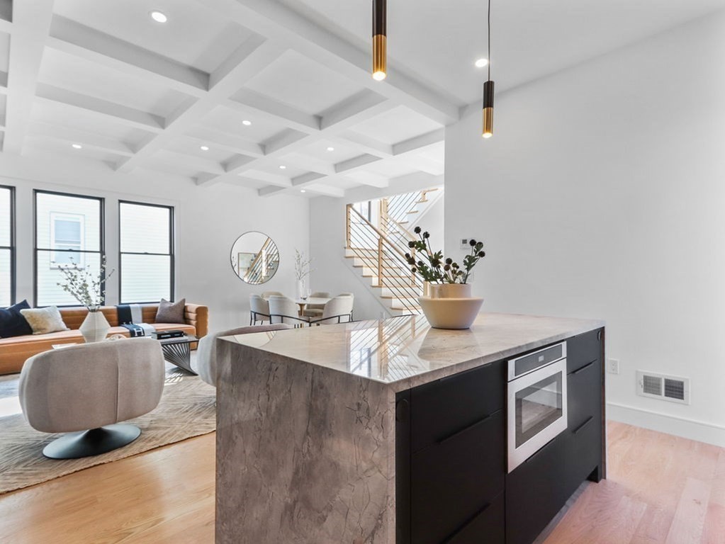 1917 Commonwealth Avenue, Unit 1917 Newton, MA 02466 - Photo 7 of 30 a living room with granite countertop furniture a chandelier a large window and wooden floor