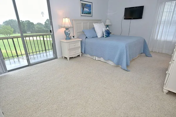 a bedroom with a balcony a bed and a window