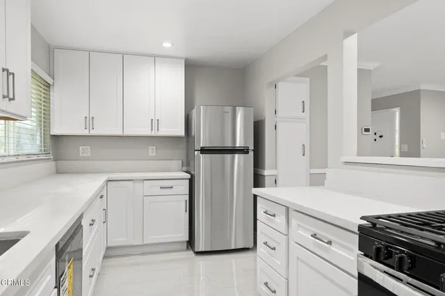 a kitchen with stainless steel appliances white cabinets and wooden floors