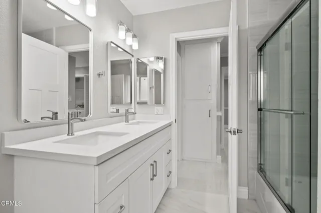 a bathroom with a double vanity sink mirror and shower