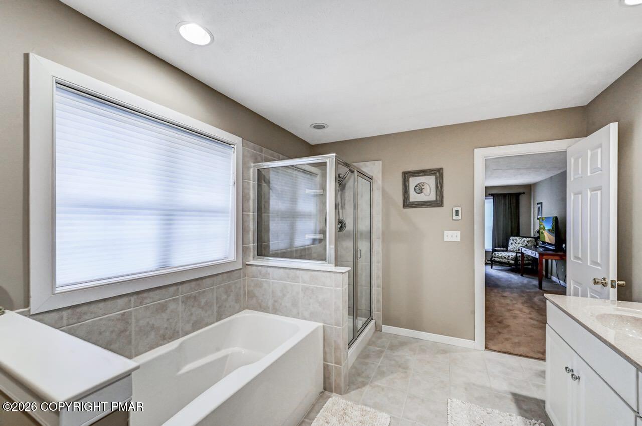 151 Skytop Road Long Pond, PA 18334 - Photo 22 of 36 a spacious bathroom with a granite countertop tub sink and mirror