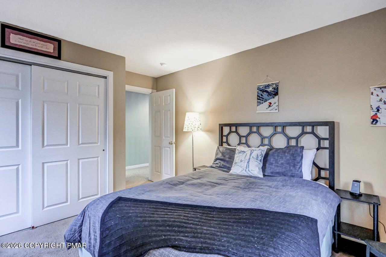 151 Skytop Road Long Pond, PA 18334 - Photo 28 of 36 a bedroom with a large bed and a chandelier