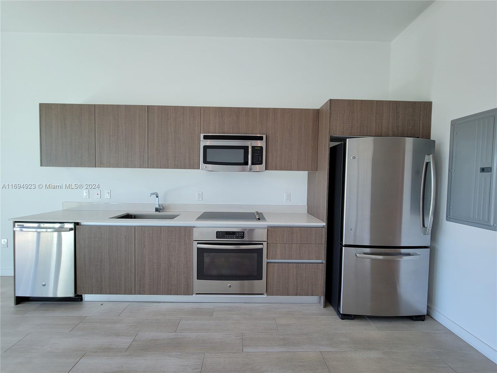 1600 Southwest 1st Avenue, Unit 411 Miami, FL 33129 - Photo 8 of 15 a kitchen with stainless steel appliances granite countertop a refrigerator a stove a sink and a microwave